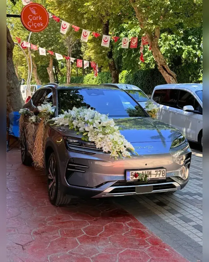 Kaputu beyaz zambaklarla ve rafya ile süslenmiş gri SUV gelin arabası